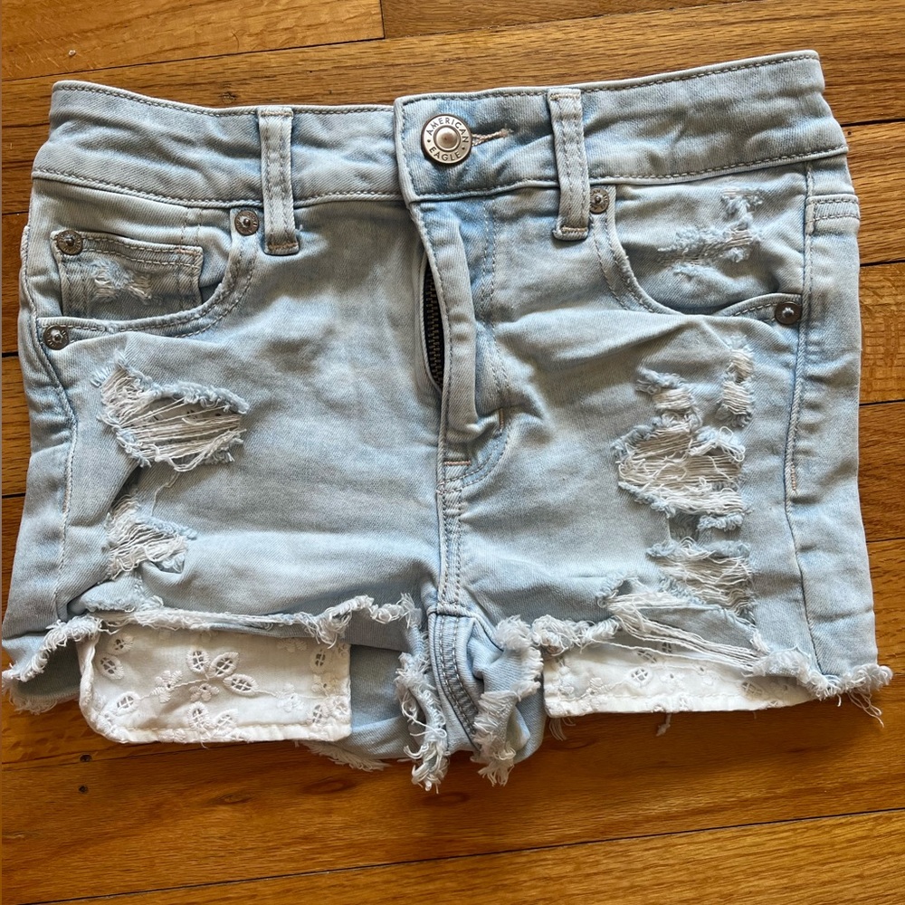 American Eagle Hi-Rise Shortie Denim Shorts Ripped with Lacey pocket details.